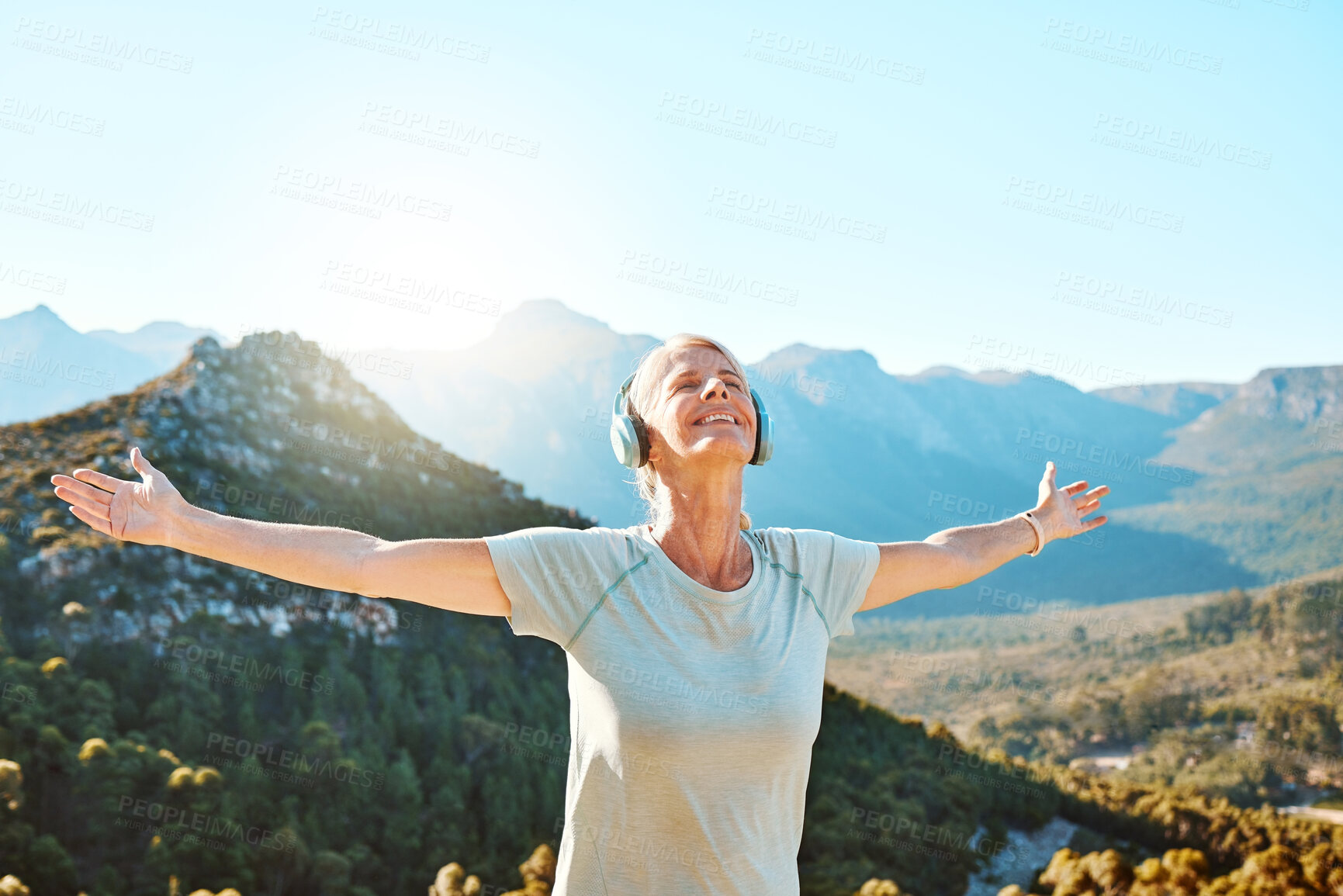 Buy stock photo Woman, headphones or freedom on mountain outdoor for fitness achievement, exercise victory or workout goals. Mature, person and happy with hands raised on hill for training success with mockup space