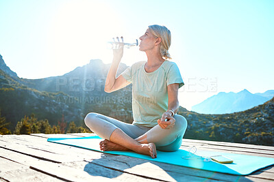 Buy stock photo Senior woman, water and drinking with mountain on mat for hydration, yoga or health and wellness in nature. Mature, female person or yogi with mineral liquid for thirst or natural sustainability