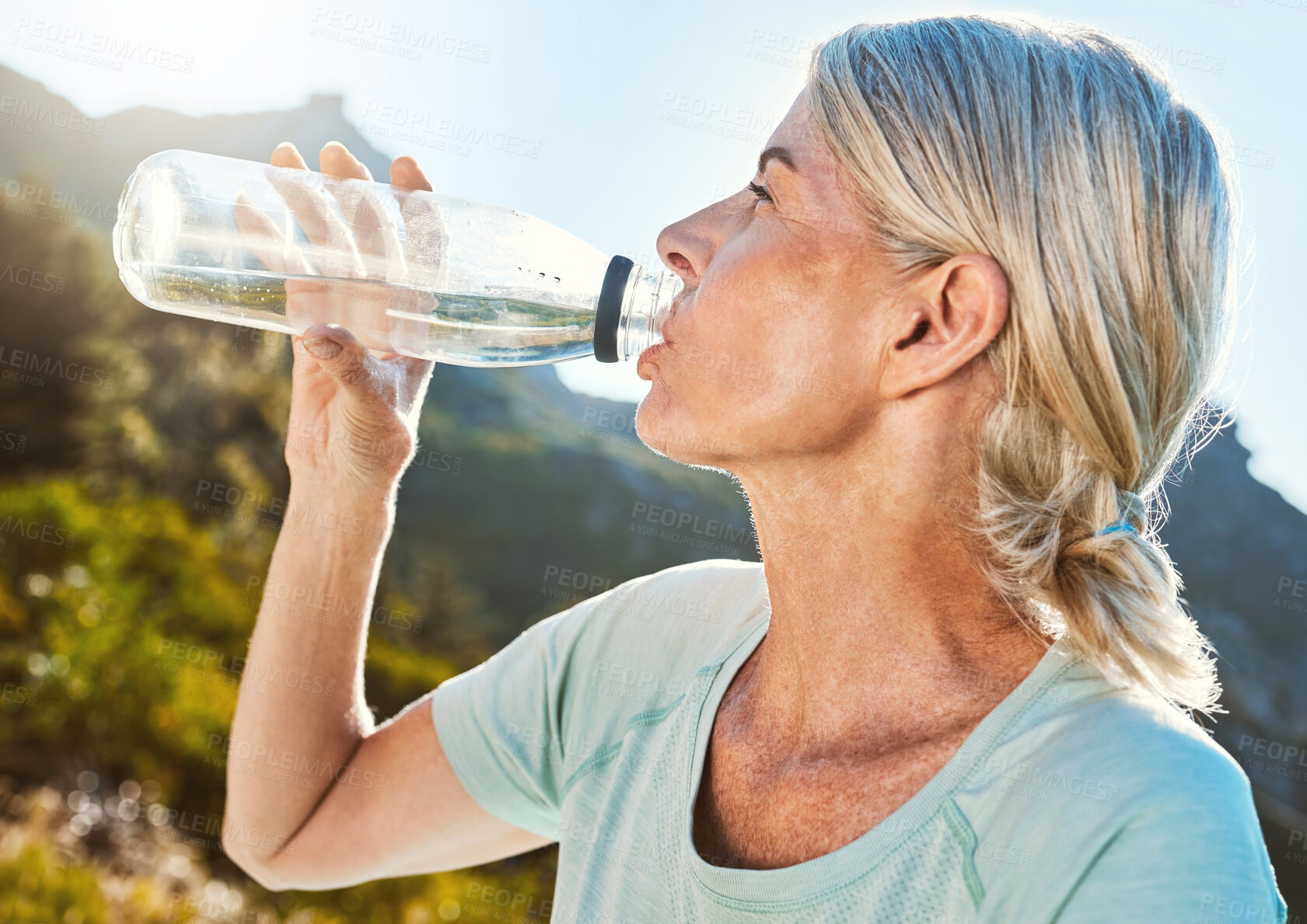 Buy stock photo Senior woman, water or drinking with bottle in nature for hydration, fitness or health and wellness on mountain. Mature, female person or yogi with mineral liquid for thirst or natural sustainability