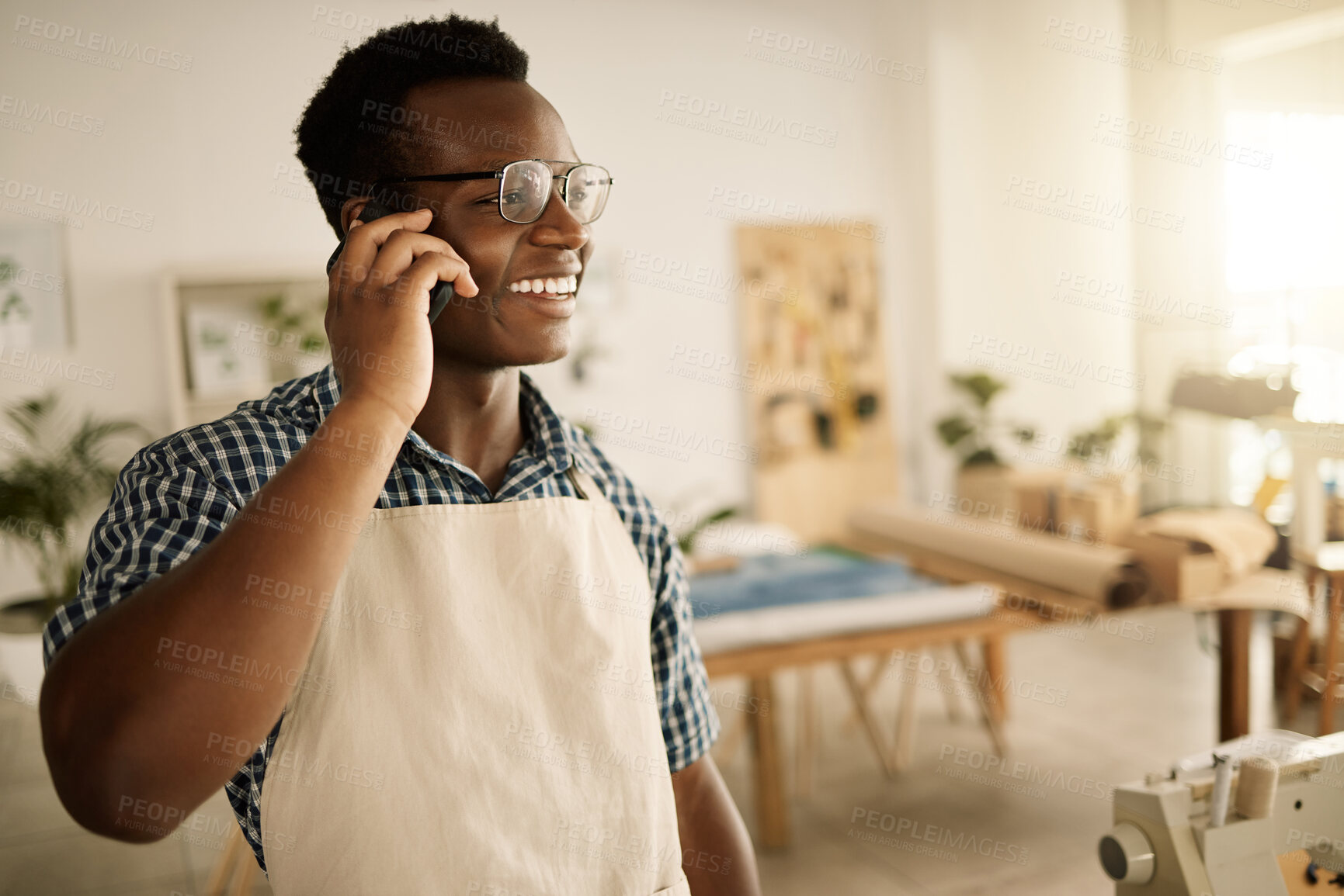 Buy stock photo Small business, black man and happy on phone call as tailor for communication and connection with client. Male person, fashion designer and smile or satisfied with clothes order at textile workshop