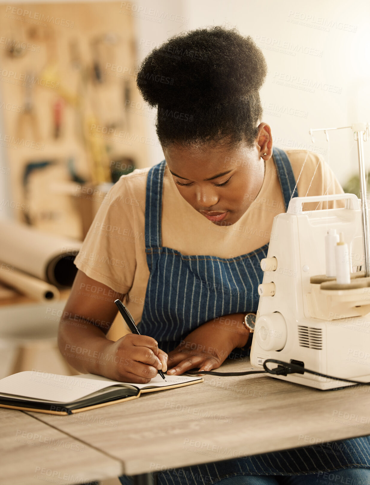 Buy stock photo Black woman, fashion designer and sketching on journal with sewing machine at creative academy. Female person, gen z and seamstress or tailor for education, learning and project with talent and skill