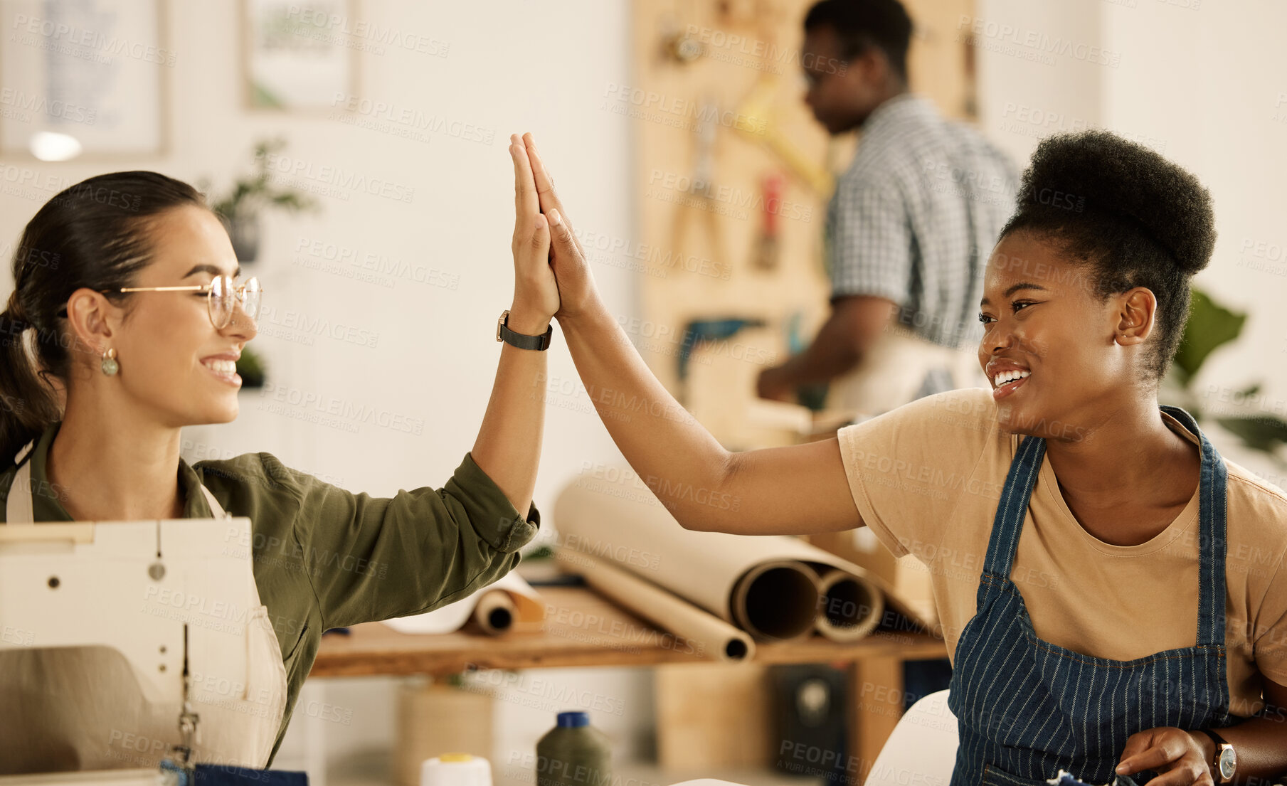 Buy stock photo Fashion, tailor and business people with high five for celebration, support and design success. Workshop, women and happy with hand gesture for manufacturing industry, textile production and teamwork