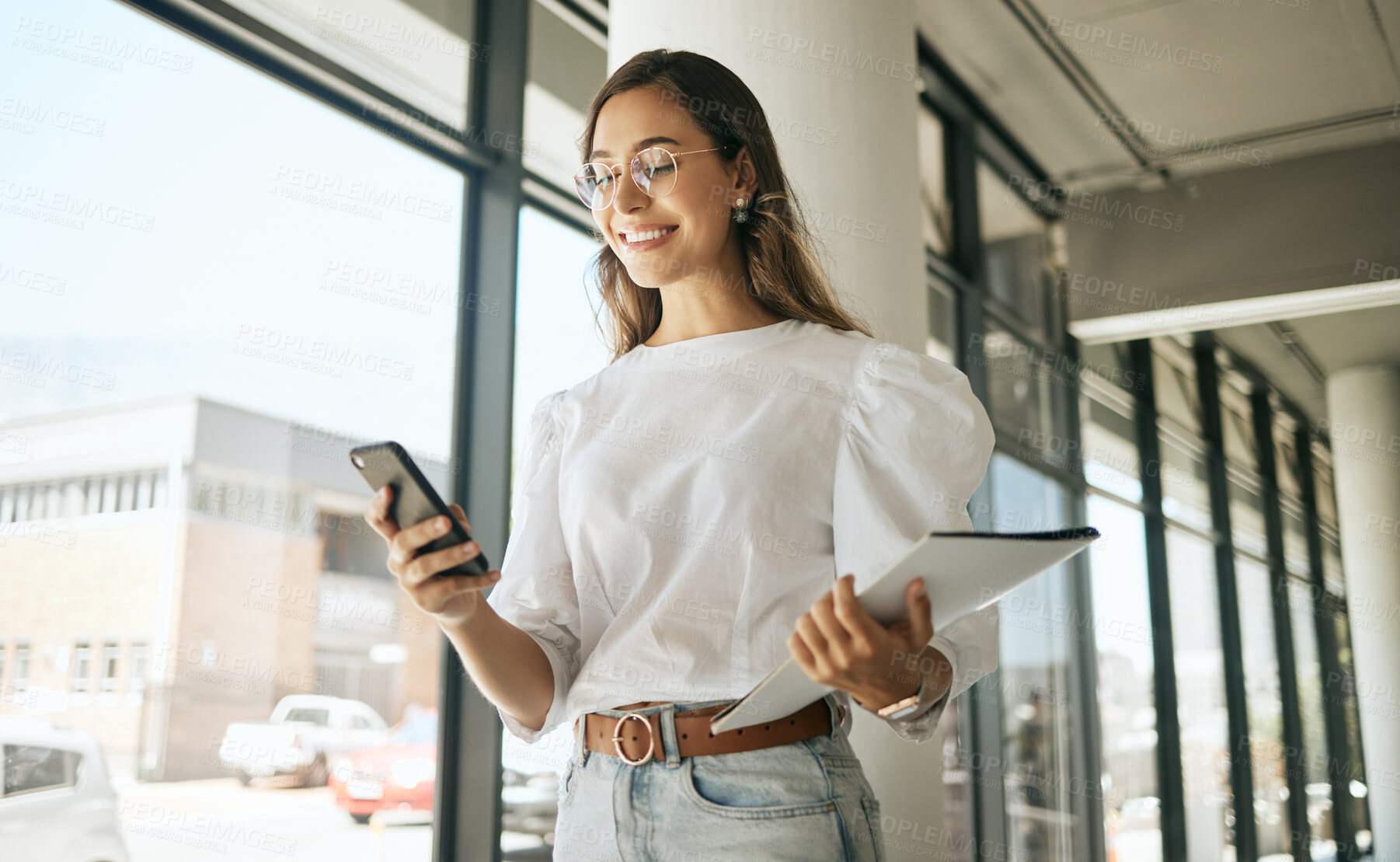 Buy stock photo Business woman, folder and smile with phone in office for text message, checking notifications and networking. Professional, employee and happy with smartphone at workplace for communication or email