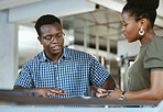 Two serious african american businesspeople having a meeting together at work. Businessman and businesswoman talking in an office. Man and woman working on a business plan