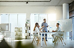 Group of diverse businesspeople having a meeting in an office at work. Young african american businessman talking while doing a presentation at a table for coworkers. Businesspeople planning together