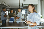 Young happy mixed race businesswoman working on a digital tablet in an office. Cheerful hispanic female businessperson wearing glasses holding and using social media on a digital tablet at work