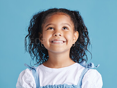 Buy stock photo Girl, child and smile with thinking in studio of happy memory, curious imagination and daydreaming. Person, kid and thoughtful on blue background with wondering, remember and ideas on mockup space