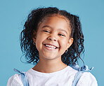 Close up head shot with smiling little brown haired girl looking up. Happy kid with good healthy teeth for dental on blue background