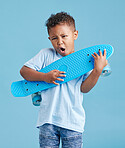 Playful kid using his skateboard as an air guitar. Adorable little mixed race boy looking excited while holding his skateboard