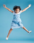 Happy young adorable little hispanic girl jumping in the air, isolated on blue background. Funny preschooler kid expressing her excitement and having fun