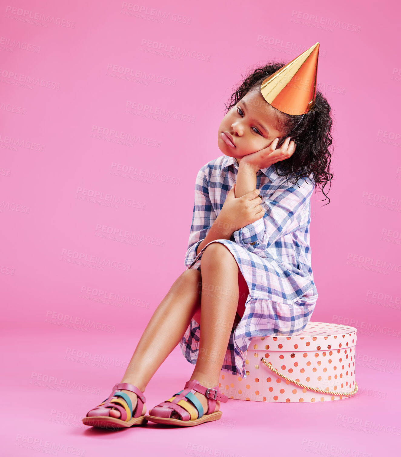 Buy stock photo Studio, birthday party and bored girl child with sad face, fatigue and unhappy on mockup space. Frustrated, tired and annoyed kid sitting on gift box with hat, thinking or isolated on pink background