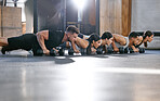 Closeup of diverse group of fit people doing bodyweight push up exercises while training together in a gym. Athletes doing press ups and plank hold to build muscle, enhance upper body, strengthen core and increase endurance for workout in fitness class