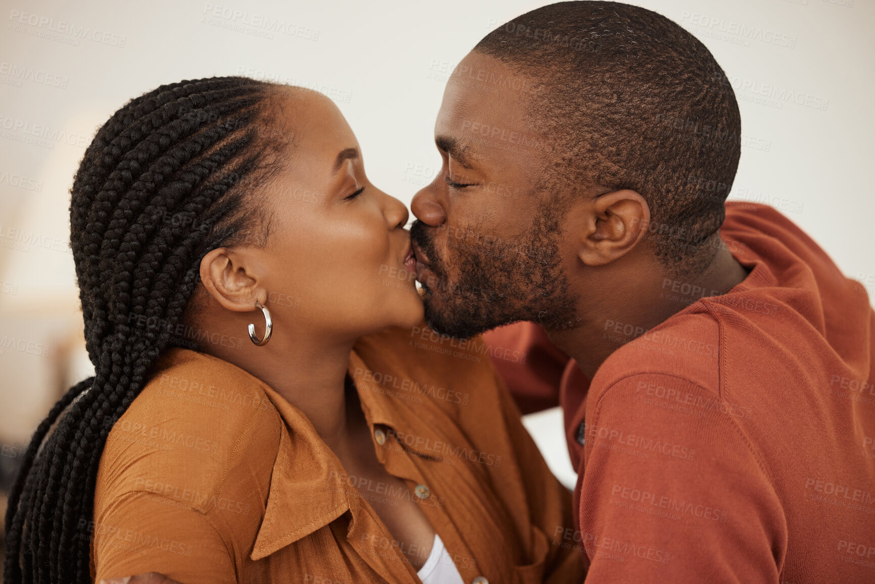 Buy stock photo Love, care and black couple in home with kiss, trust and support in happy relationship together. Man, woman and relax in romantic embrace with partner bonding, marriage and weekend date in apartment