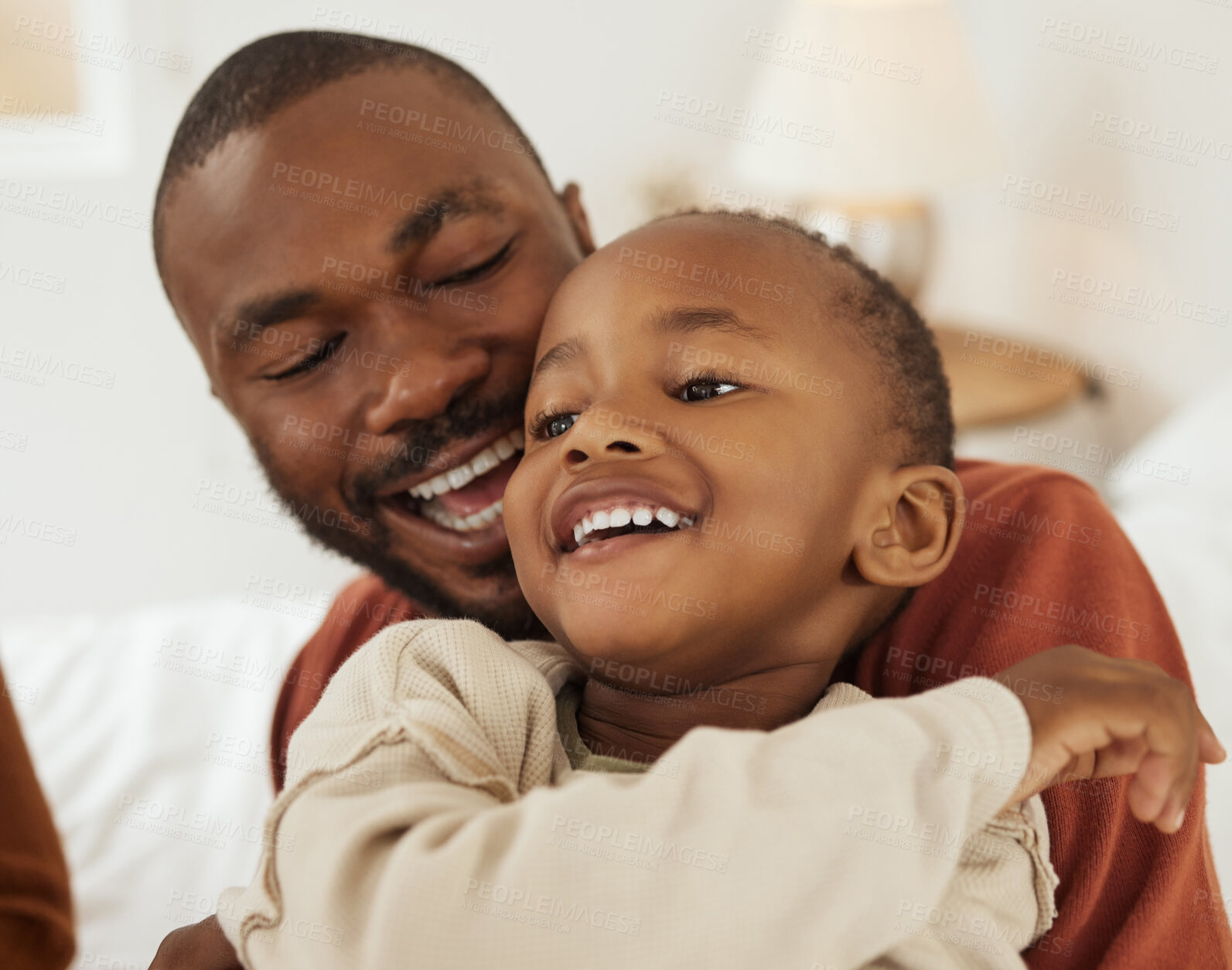 Buy stock photo Happy, African and dad with kid on bed for bonding, relax together and playful relationship in morning. Family, love and father with young boy hug in bedroom for playing, fun and laughing in home