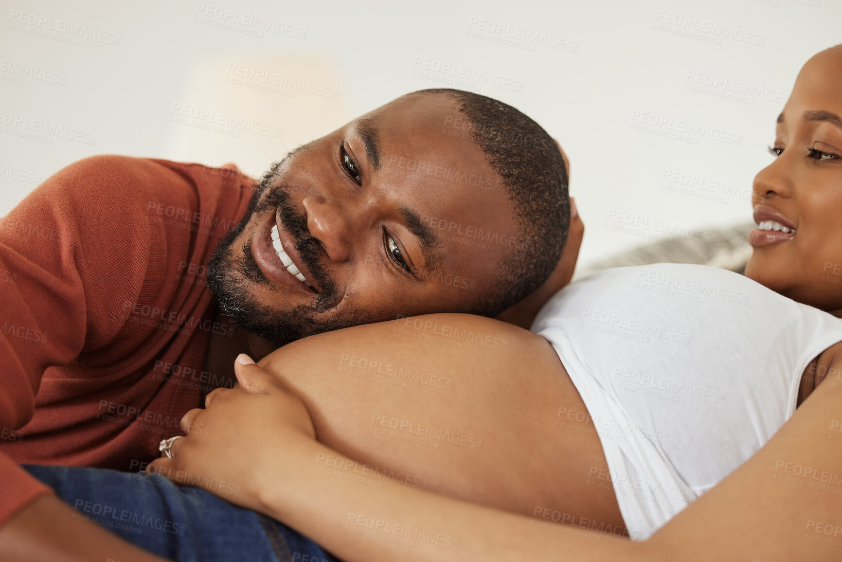 Buy stock photo Black man, pregnant woman and listen with belly in bedroom with smile, excited and bonding in home. Couple, parents and happy with stomach, baby and kicking with connection in morning at apartment