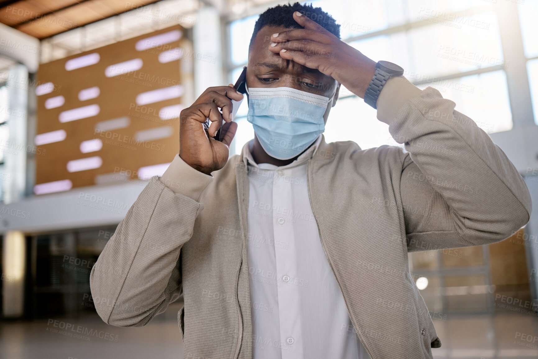 Buy stock photo Black man, mask and phone call at train station for travel, conversation or terminal with stress for delay. Person, listening and ppe with headache, smartphone and worry for schedule on business trip