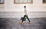 Black businessman travelling alone.A african american businessman walking around town with his luggage while wearing mask to protect himself from the corona virus in the city