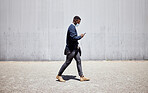 Businessman wearing face mask while commuting during the covid pandemic. Man using cellphone while walking to work. Using internet while walking in the city. Man using internet while commuting