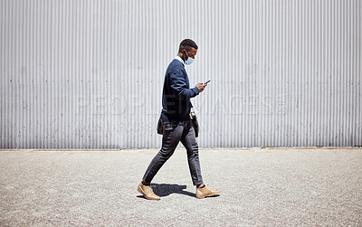 Buy stock photo Black man, face mask and phone for travel outdoor with compliance, health safety and morning journey. Male person, mobile and walking for healthcare policy, commute delay or ppe protocol of transport