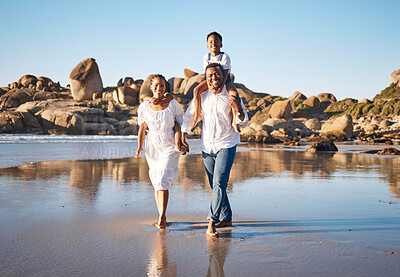 Buy stock photo Family, portrait and walking at beach for bonding, travel and vacation with support, care and carrying. Parents, children and holding hands for relationship, relax and holiday with blue sky as people