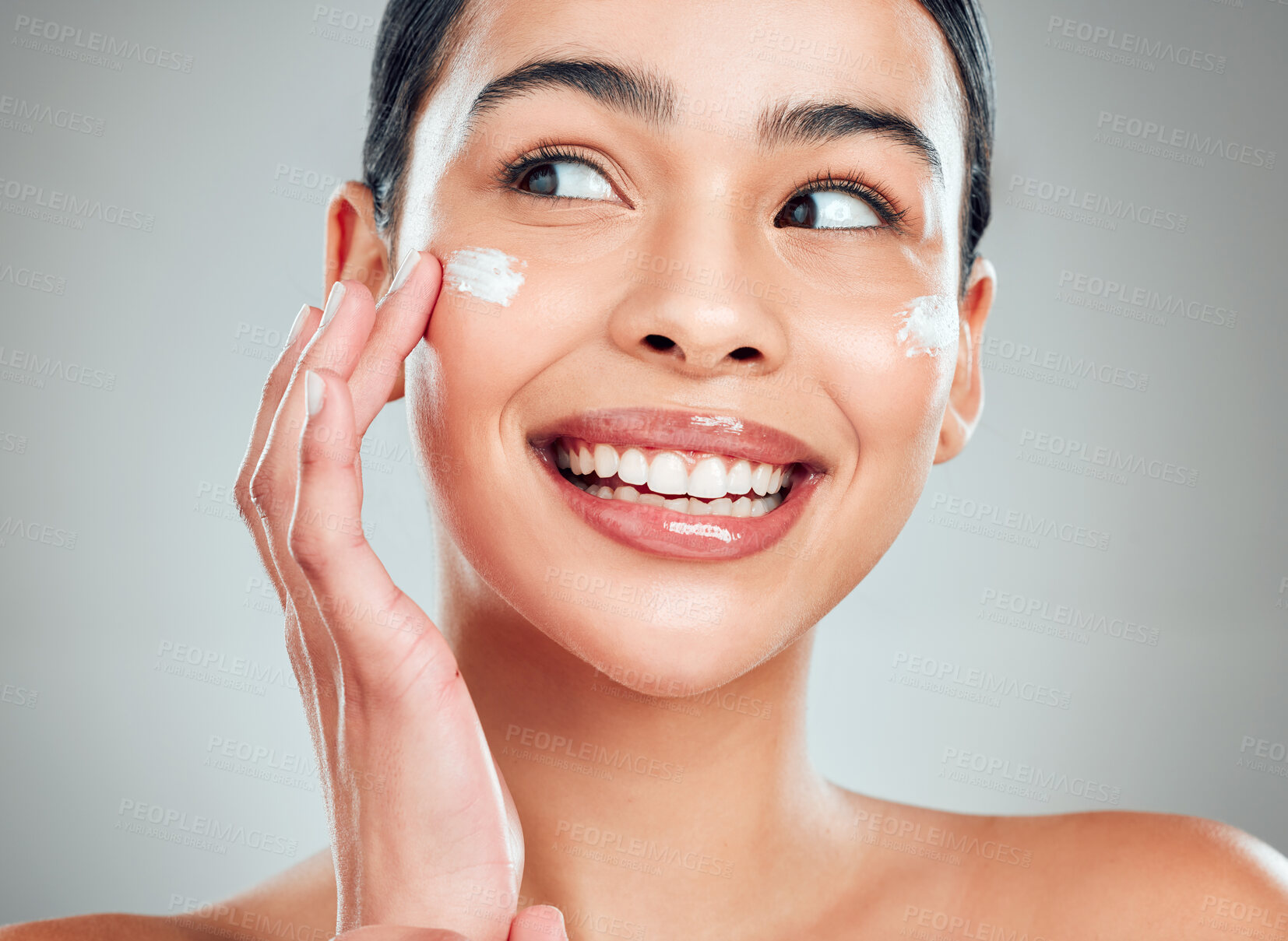 Buy stock photo Face cream, skincare and happy woman in studio with glow, hydration and wellness. Beauty, health and female person from Cuba with moisturizer for facial dermatology routine by gray background.