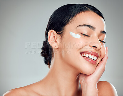 Buy stock photo Face cream, skincare and woman with cosmetics in studio with nourishment, hydration and glow. Happy, health and female person with moisturizer for facial dermatology routine by gray background.