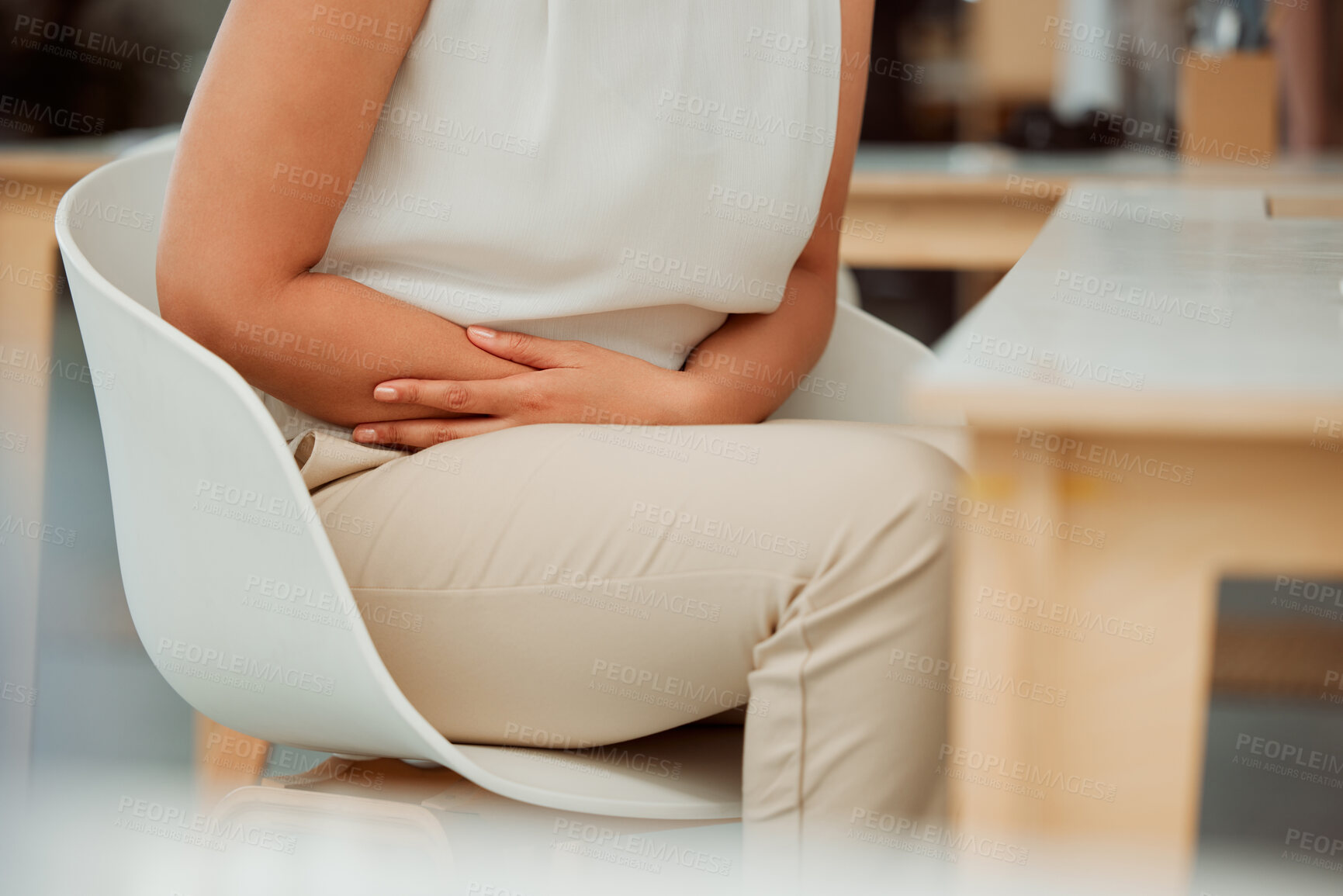 Buy stock photo Business woman, hands and stomach ache with pain, digestion or sore gut on chair at office. Closeup, female person or employee with gastro, reflux or abdominal cramps for period or menstrual cycle