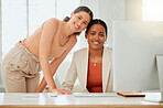 Portrait of two confident young hispanic business women working together on a computer in an office. Happy ambitious colleagues and close friends posing with heads touching in a creative startup agency