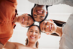 Portrait of happy businesswomen joining their heads together in a circle in an office at work. Diverse group of cheerful businesspeople having fun standing with their heads together in unity