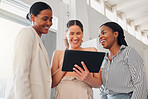 Group of cheerful businesswomen talking and working on a digital tablet together at work. Joyful businesspeople talking and planning while standing in an office