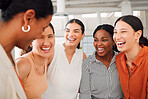 Diverse group of five cheerful businesswomen having a meeting together in at work. Joyful businesspeople talking and laughing while standing in an office