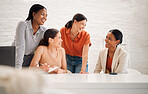 Group of happy diverse businesswomen having a meeting together in a boardroom at work. Cheerful businesspeople laughing and talking while planning in a workshop in an office