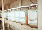 Glass jars of spices lined up in a row on a display shelf in a grocery store. Fresh produce from the farmer's market. Get to your local green grocer for all your cooking, spice and flavouring needs