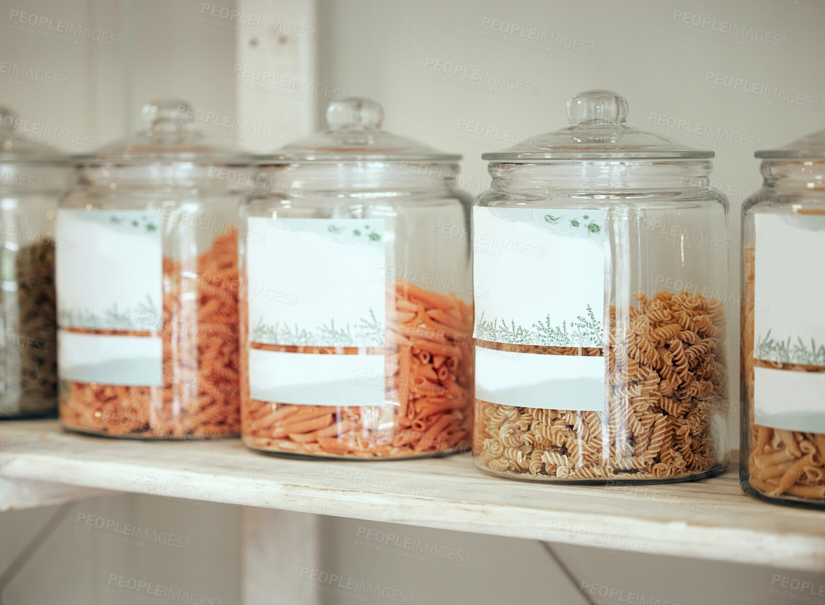 Buy stock photo Jars, variety and pasta in kitchen storage for nutrition, healthy diet and organic food in pantry. Display, macaroni and selection of fusilli, penne and rotini ingredient in container on wooden shelf