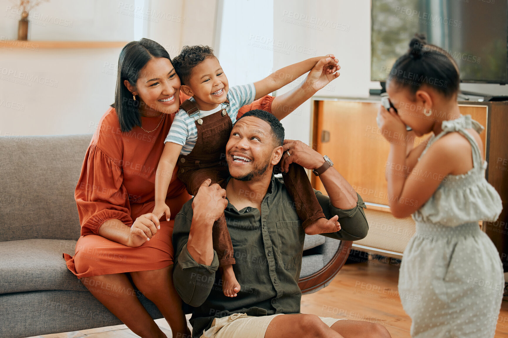 Buy stock photo Support, airplane and picture with family on sofa for love, playful game and photography. Care, bonding and memory with child on shoulders of parent in living room at home for silly, camera and funny