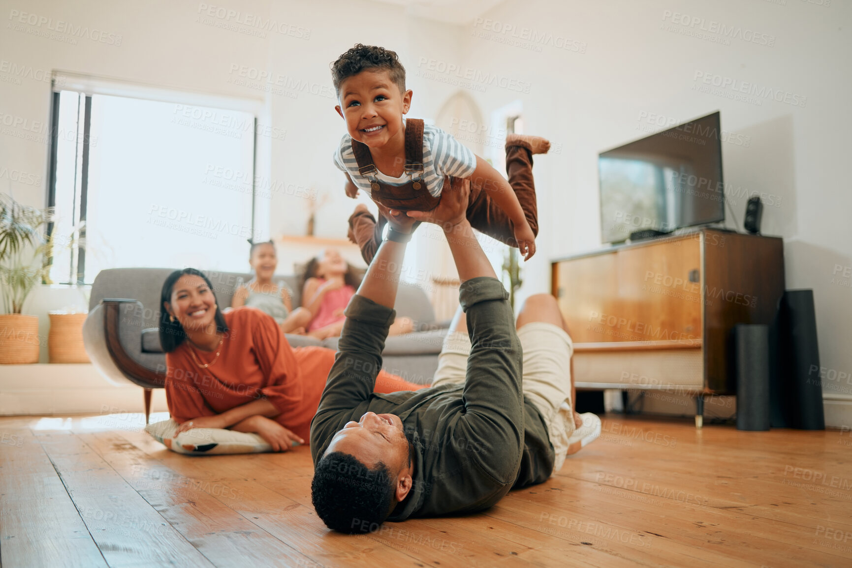 Buy stock photo Bonding, airplane and lifting with family on floor for love, playful game and happiness. Care, support and laughing with child and parents in living room at home for silly, comedy and funny
