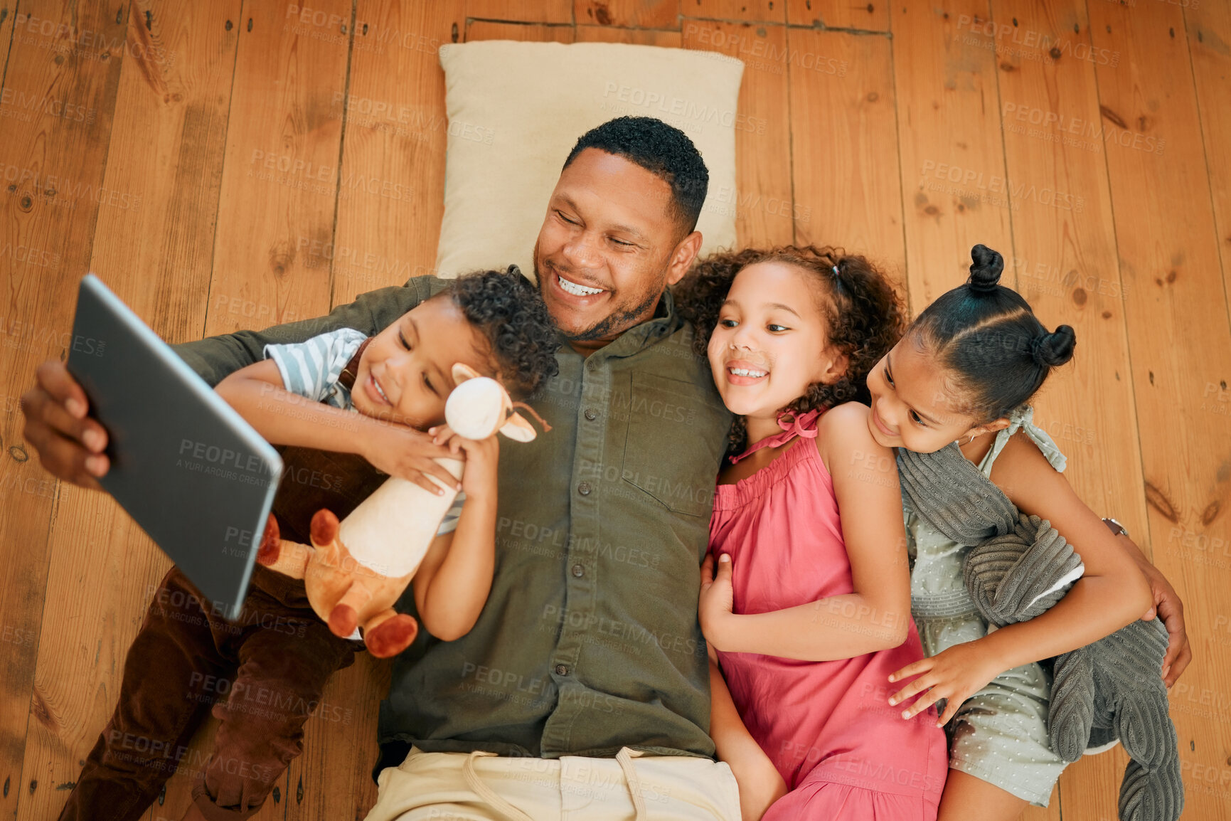 Buy stock photo Tablet, above and smile with father and kids on floor for love, streaming and happiness. Care, movies and hug with man and children in living room of family home for support, social media or lounge