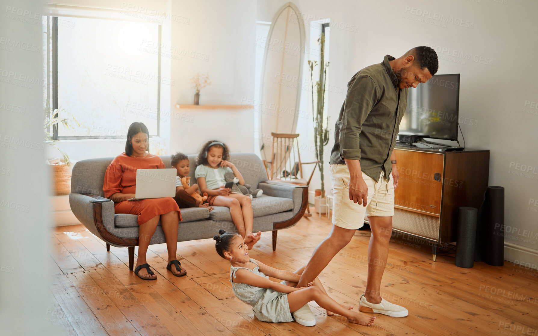 Buy stock photo Happy, home and child on leg of father for playing, fun and goofy joke together in living room. Family, relax and girl kid clinging dad for bonding, connection and comedy in lounge at house.