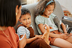 Closeup of a mixed race single parent teaching her son a lesson about sharing while his sister is using a cellphone and headphones. A single parent putting her son in timeout for his bad behaviour