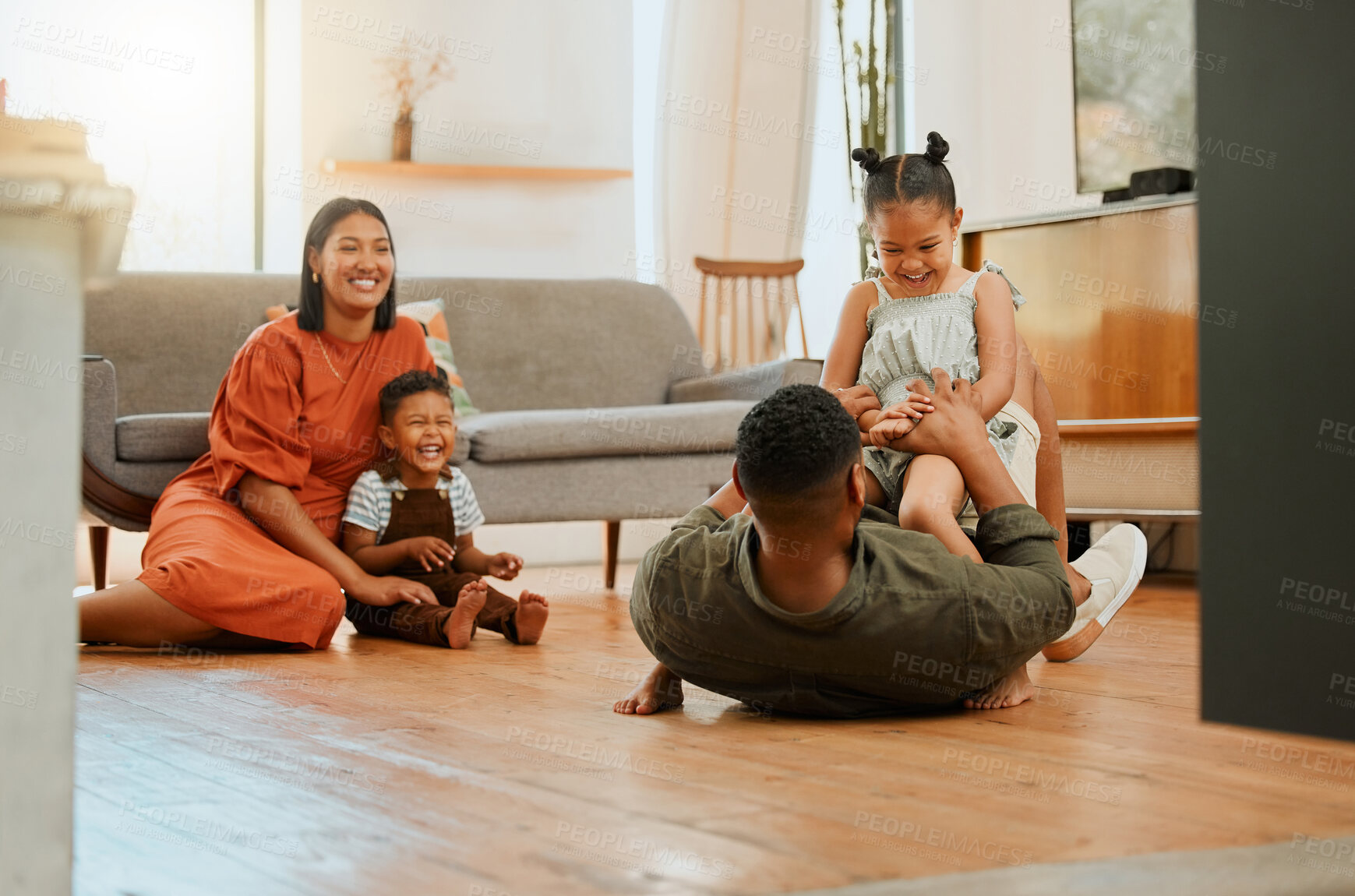 Buy stock photo Funny, playful and bonding with family on floor in lounge for love, game and happiness together. Care, energy and laughing with parents and children in living room at home for silly, comedy and joke