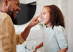 Happy mixed race father and daughter washing their hands  together in a bathroom at home. Single African American parent teaching his daughter about hygiene while having fun and being playful