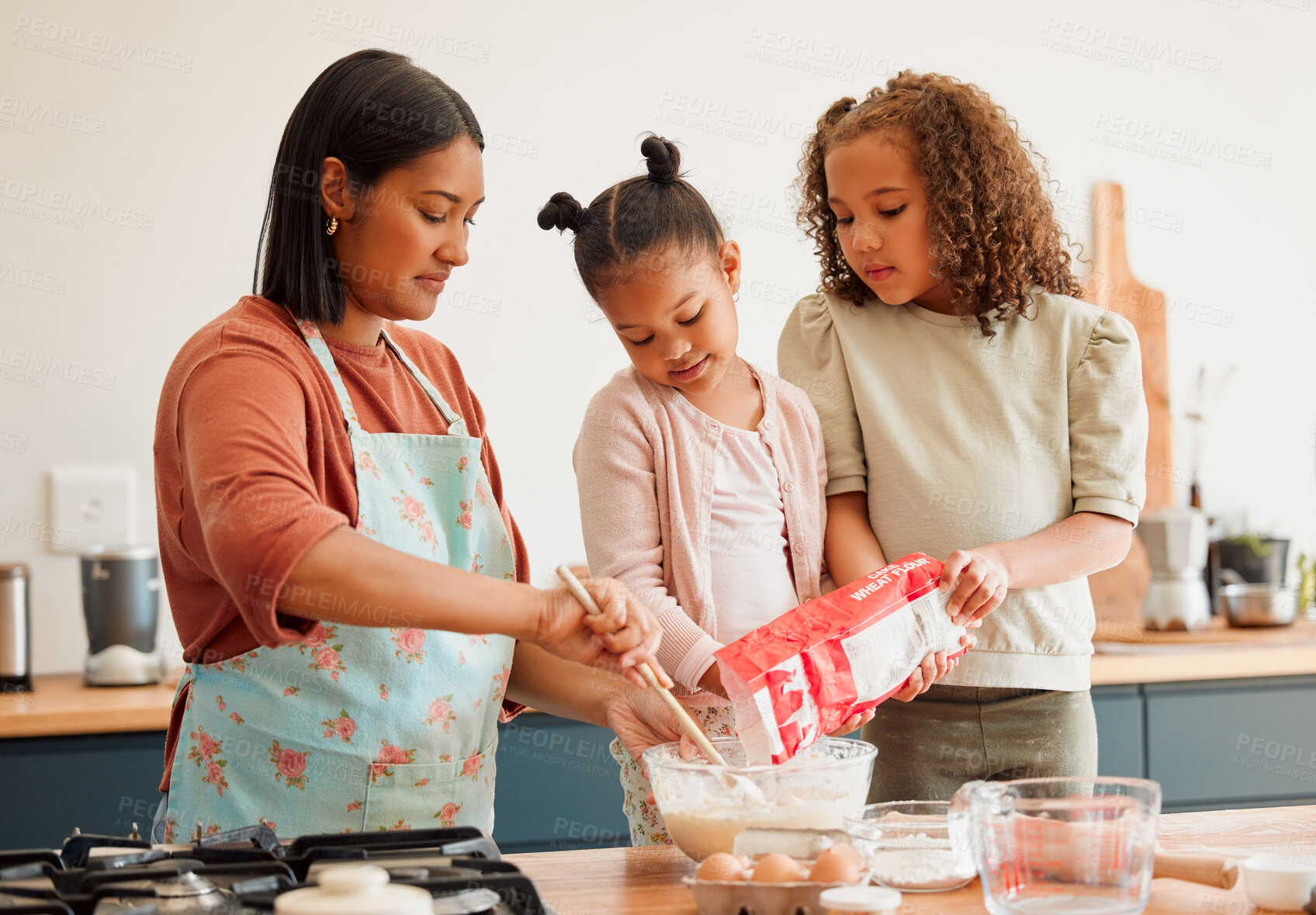 Buy stock photo Children, woman and help with baking in kitchen for support, development and learning cooking recipe. Family, mother and kids pouring flour in bowl on table for ingredients, preparation and teaching