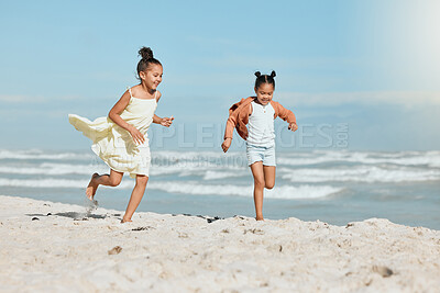 Buy stock photo Happy girls, siblings and running with beach sand for holiday, weekend or bonding together in nature. Young, sisters or kids playing on ocean coast by waves for fun summer or outdoor vacation at sea