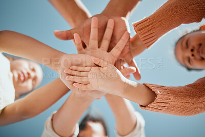 Buy stock photo Kids, hands together or unity below with blue sky for community, care or trust in support. Low angle, closeup or people piling in solidarity or union for motivation, youth or friendship in nature