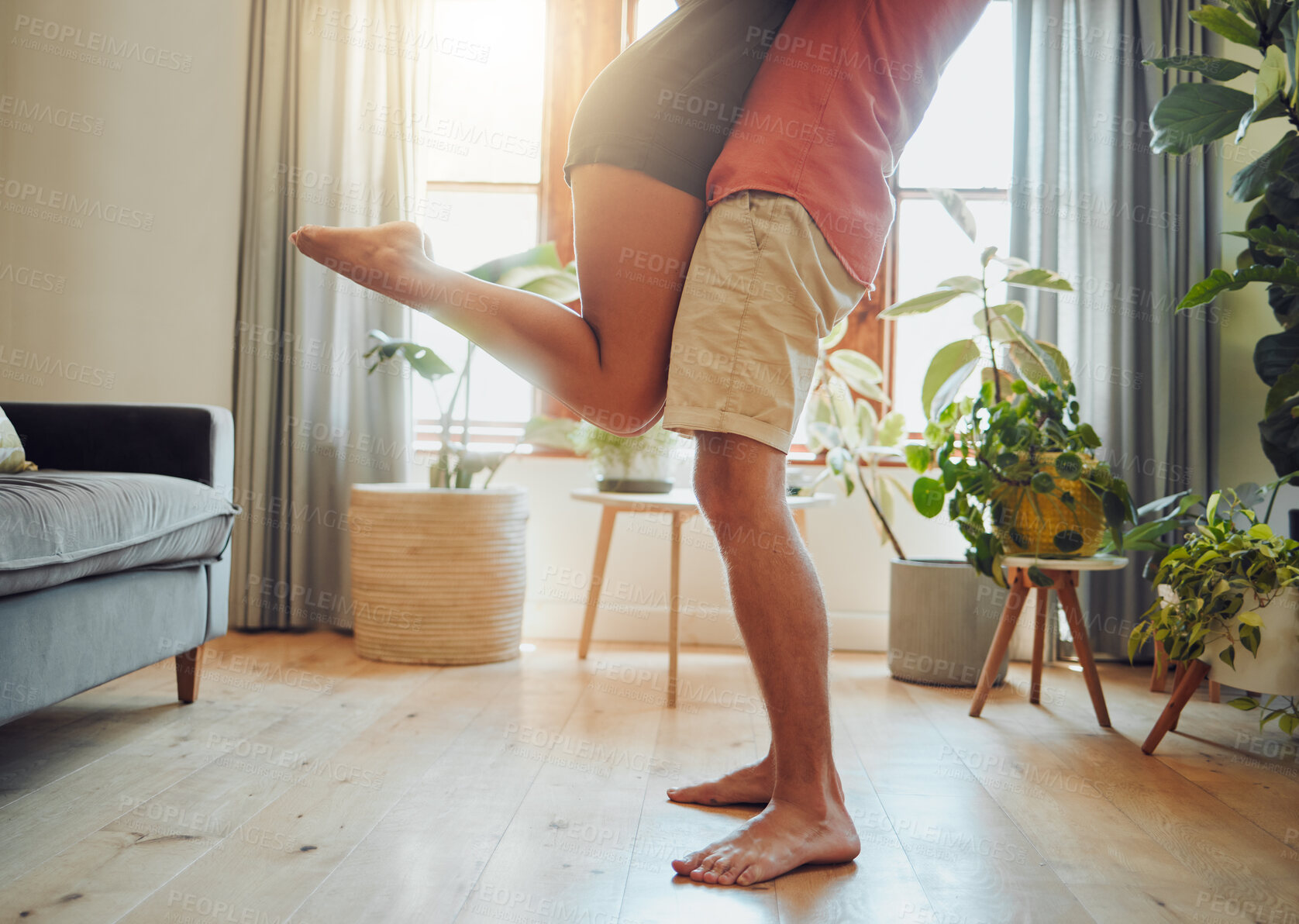 Buy stock photo Couple, legs and lifting woman in home, support wife and love in relationship or fun. People, feet and bonding in apartment for care in marriage, connection and holding for trust in partnership