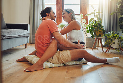 Buy stock photo Funny, love and happy couple hug on floor in home for care, connection or talking together to relax on cushions. Embrace, man and woman laugh in living room for joke, comedy and healthy relationship