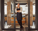 Confident mixed race businessman standing in his store. Proud businessman arms crossed standing in his shop entrance. Portrait of small business owner standing in his restaurant alone.