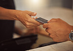 Customer paying with a credit card in a cafe. Closeup of a customer paying a barista in a restaurant. Hands of a shop assistant taking a debit card from a customer. Customer making a card payment