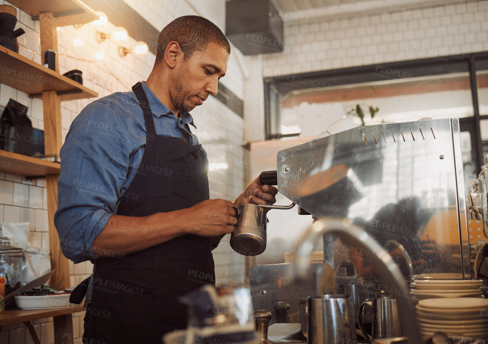 Buy stock photo Barista, milk and steam with coffee machine in cafe for espresso, cappuccino and latte with hospitality. African man, jug and froth in restaurant kitchen for warm drink, foam and professional service