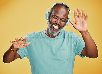 Buy stock photo Black man, headphones and dancing in studio, hearing audio and streaming radio on yellow background. Mature person, energy and confident connection to song, technology and online for hip hop playlist